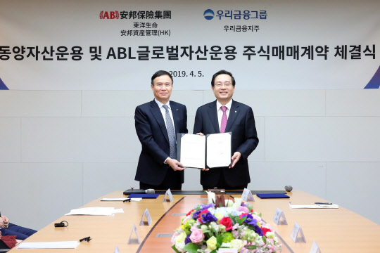 지난 5일 서울 소공동 한진빌딩 본관에서 손태승 우리금융그룹 회장(오른쪽)과 뤄젠룽 동양생명 사장이 SPA(주식매매계약) 체결 기념사진을 촬영하고 있다.  우리금융지주 제공